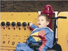 photo of a boy using a wheelchair at an interactive panel